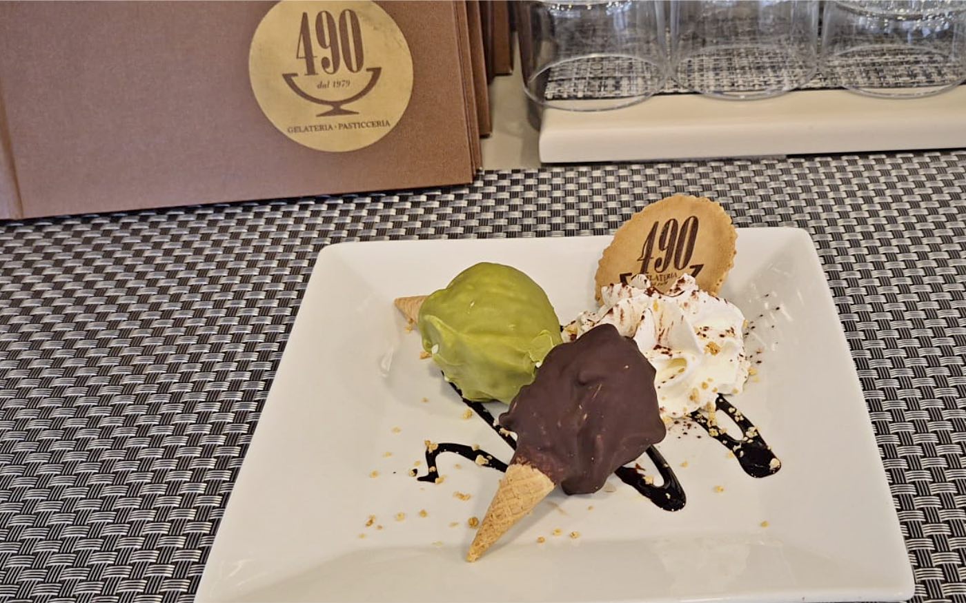 Due capricetti del 490: coni di gelato ricoperti di pistacchio e cioccolato, con panna, granella e la cialda firmata
