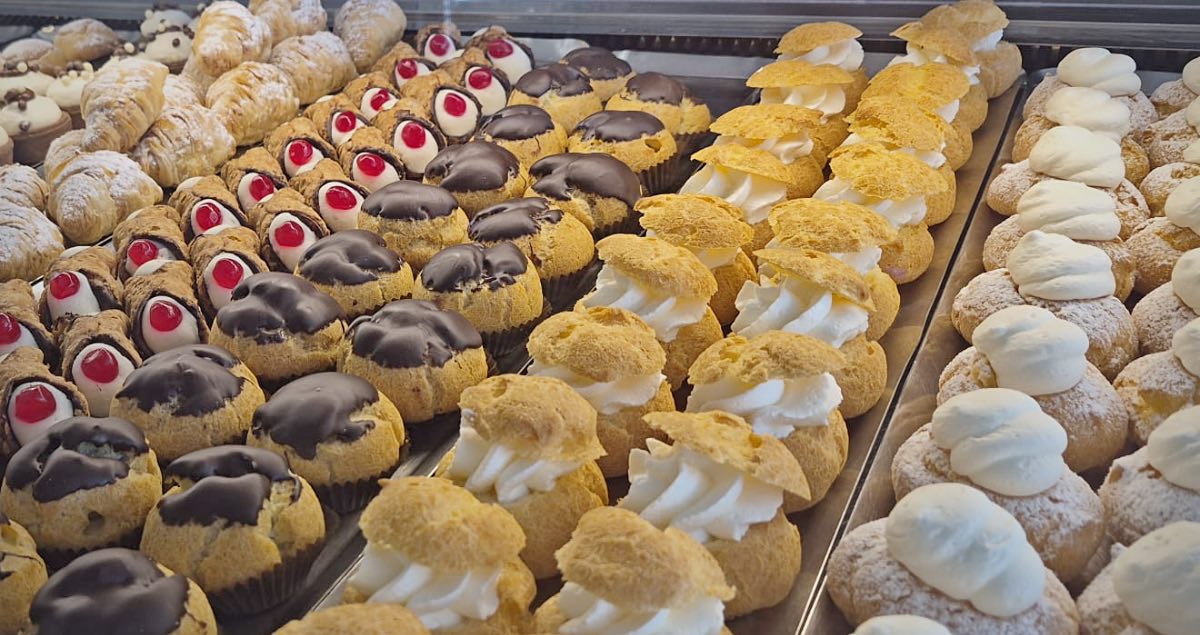 Paste alla crema e all'amarena nella vetrina della pasticceria 490