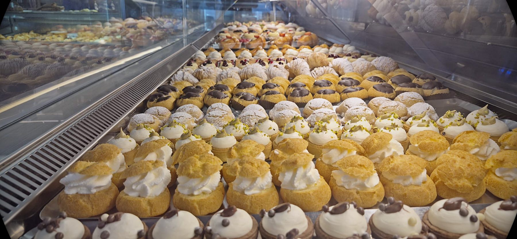 Il banco della pasticceria del 490 con i bignè, le paste alla crema e i vassoi del giorno