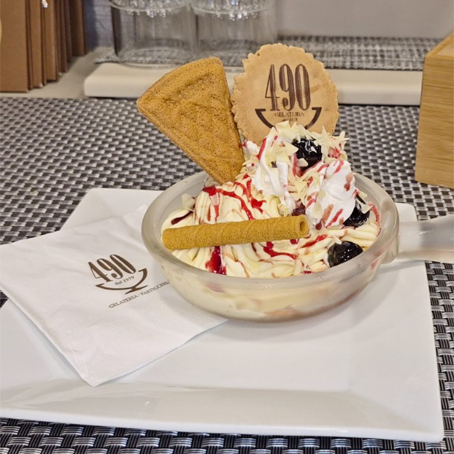 Primo piano degli spaghetti di gelato alla vaniglia con lo sciroppo di fragola e le amarene